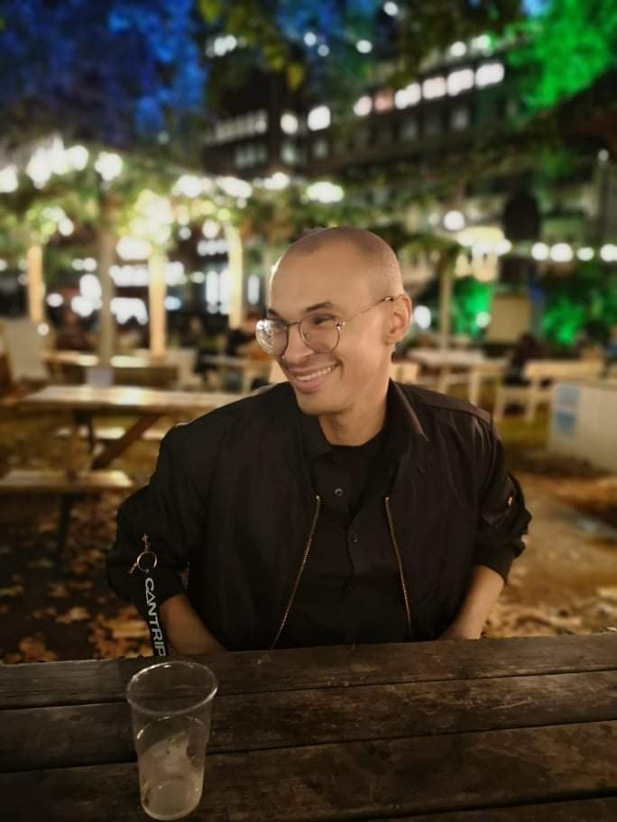 a person smiling in a beer garden at night